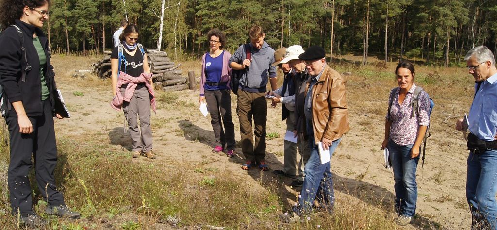 Mitglieder der Projektbegleitenden Arbeitsgruppe und die Maßnahmenbetreuer diskutieren die Naturschutzmaßnahmen im Projektgebiet "Hirschackerwald"