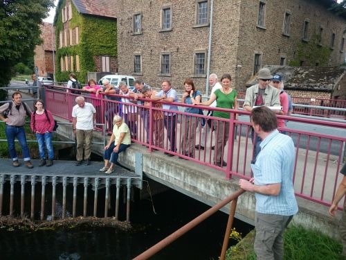 Martin Grund (vorne rechts) erläutert am Speyerbach die  Funktionsweise der Wasserableitung